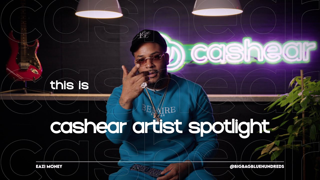 Eazi Money in a blue Belaire crewneck, cap, and tinted glasses on the Artist Spotlight set
