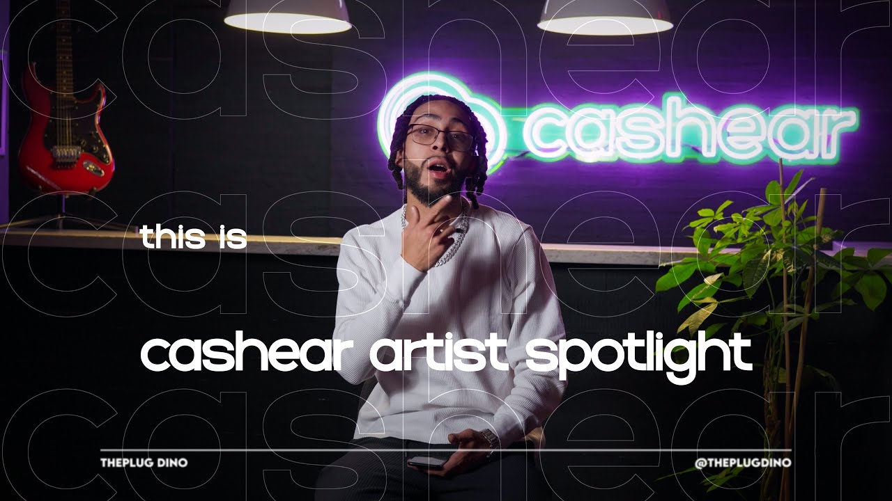 ThePlug Dino in a white sweater mid sentence on the Artist Spotlight set, lit by the neon cashear sign