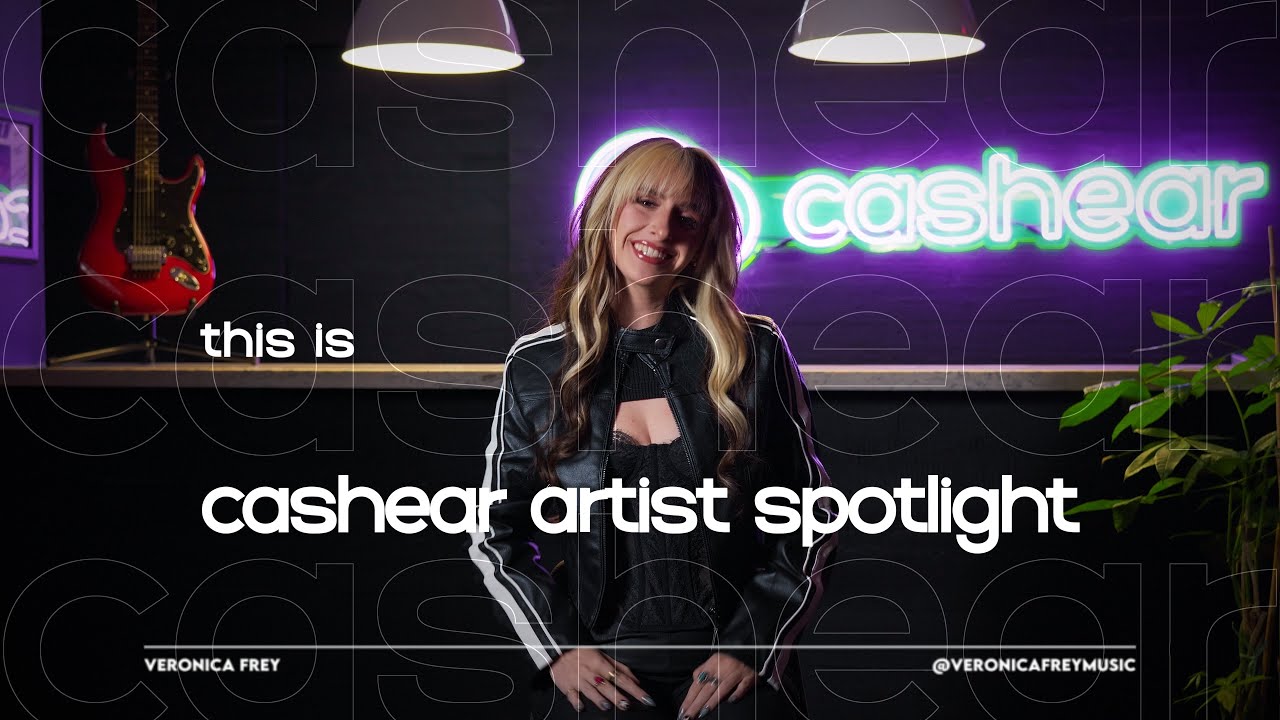 Veronica Frey smiling in a leather jacket on the Artist Spotlight set, the neon cashear sign glowing behind her