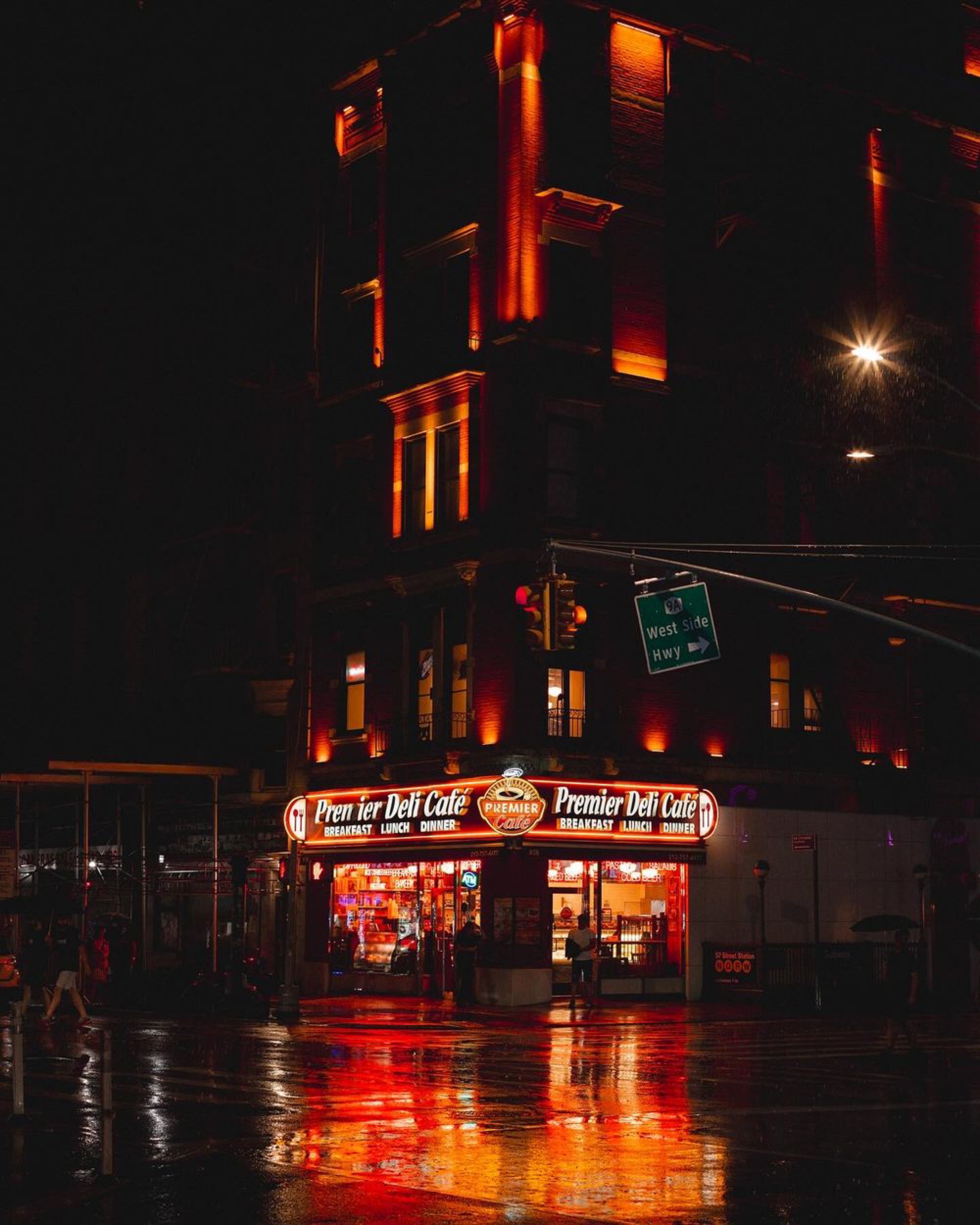 Corner store glowing with warm red neon light reflecting on a wet city street