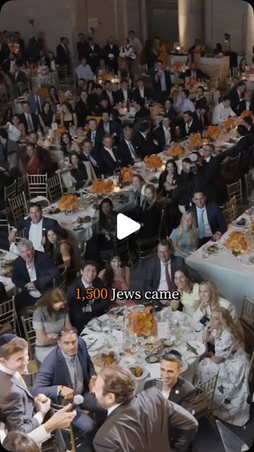 A gala floor of round tables with orange centerpieces seen from above, 1,500 guests seated