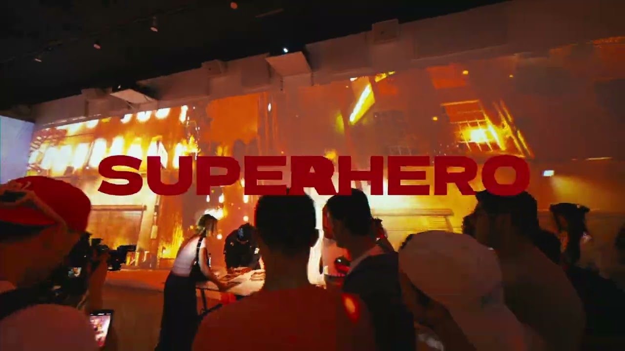 The word SUPERHERO in red across a wall sized comic projection above a crowd at the Metro Boomin experience