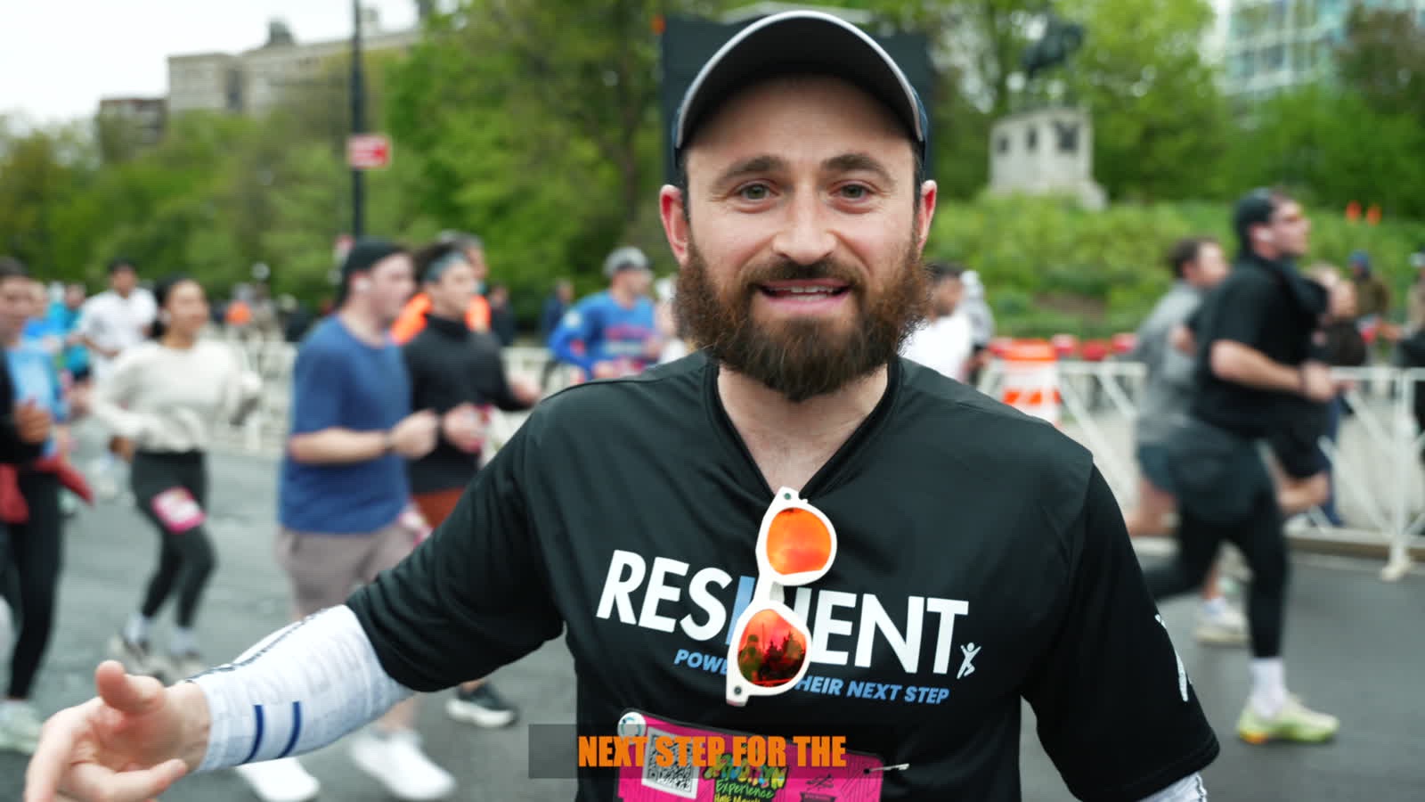 Opening frame of the Brooklyn Half film: a runner in a Resilient shirt on the course with the field behind