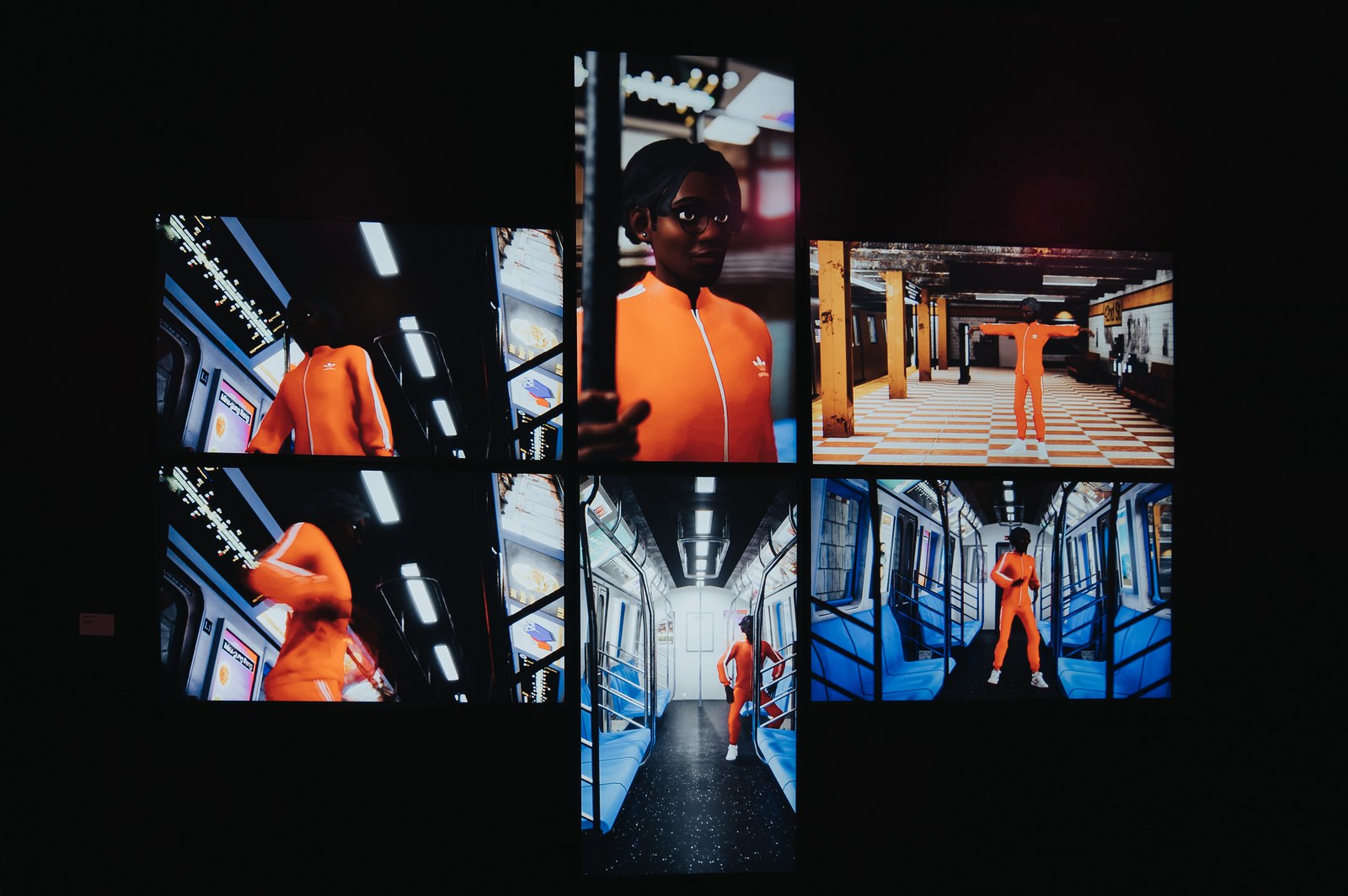 Multi screen video wall showing a figure in an orange tracksuit inside a subway car against a dark room