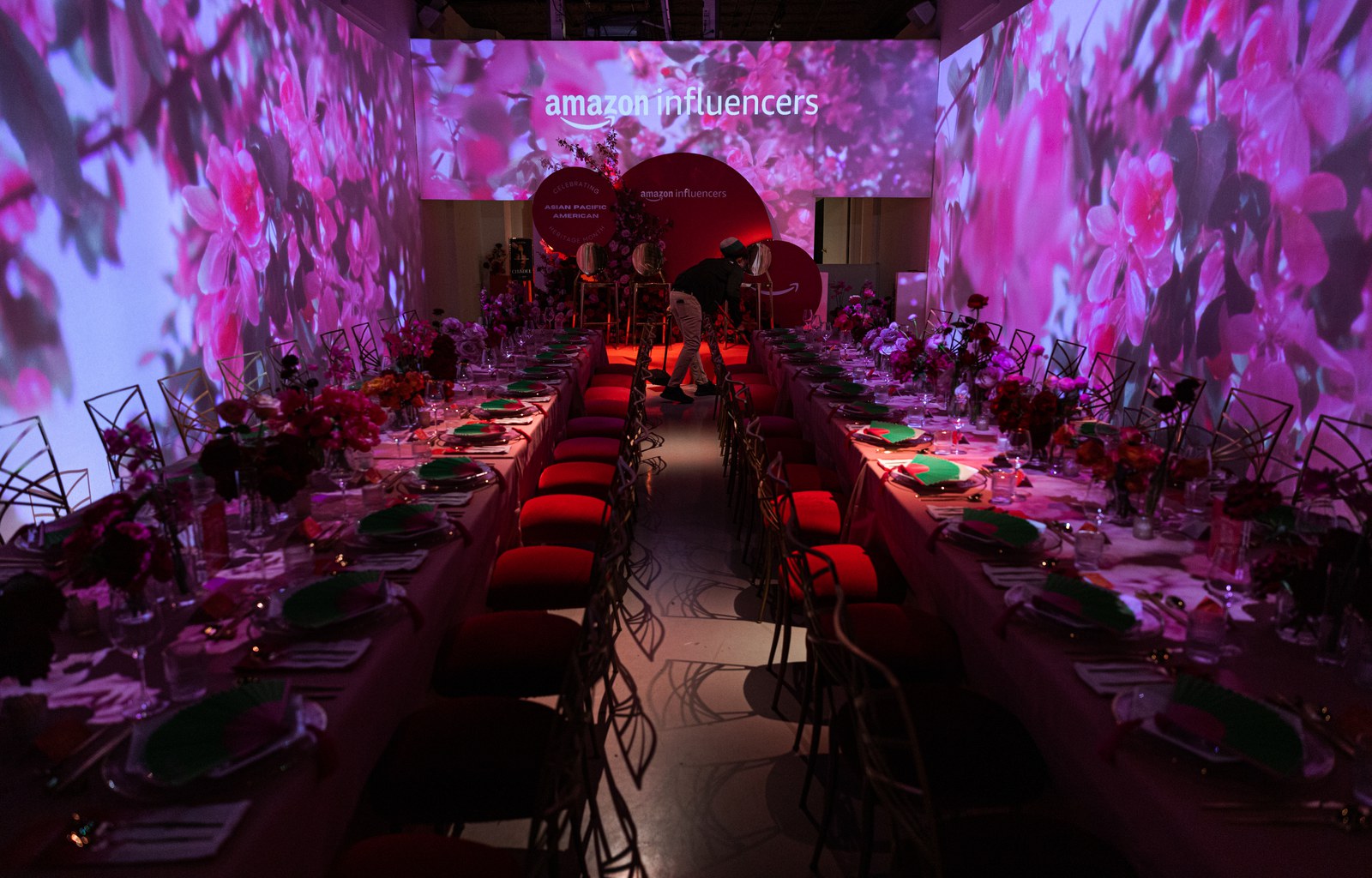 Plated dinner course beside wine glasses and pink roses on a candlelit table