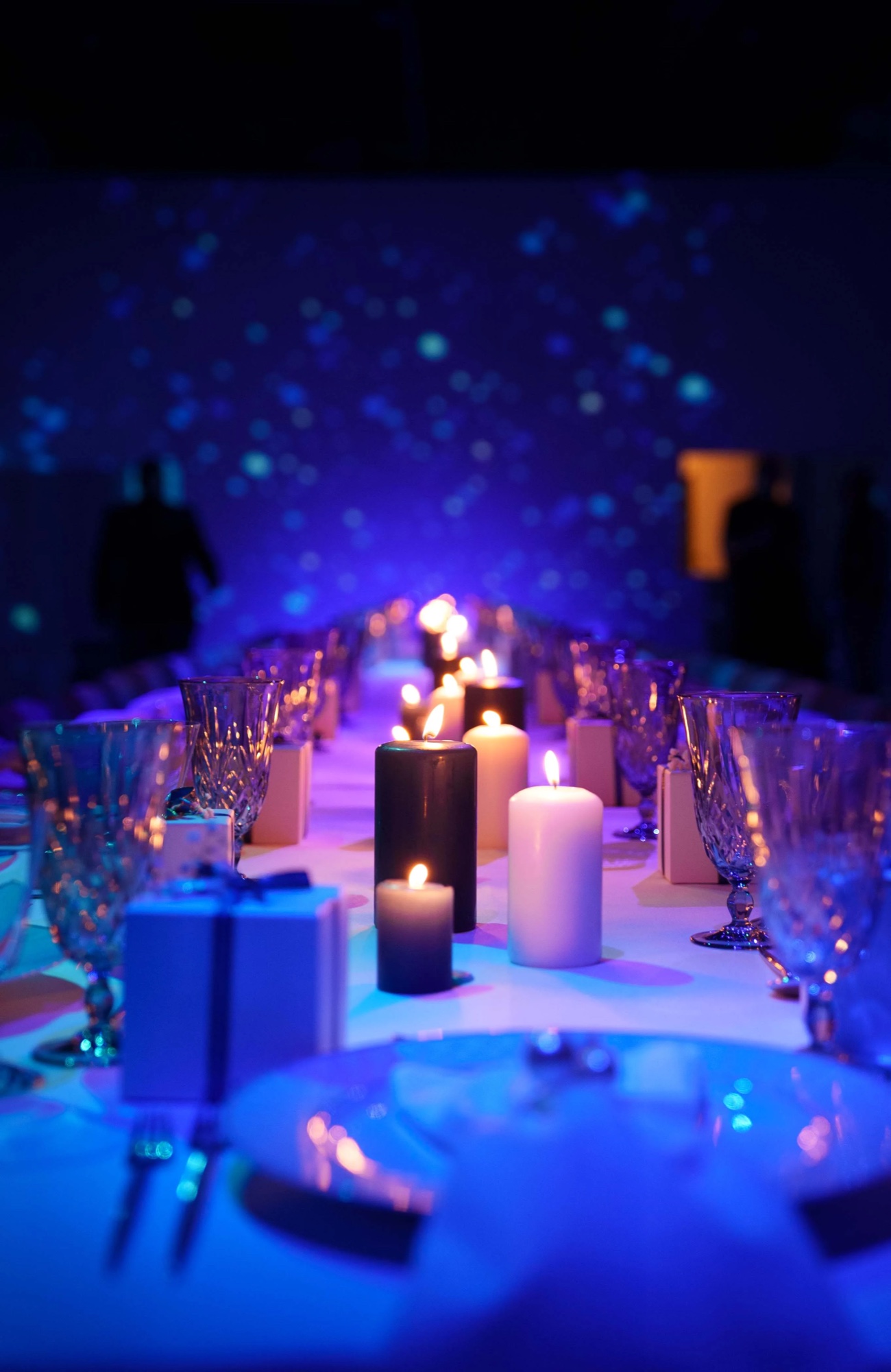 Black and white pillar candles and a gift box in shallow focus on the Cache by Bridge dinner table