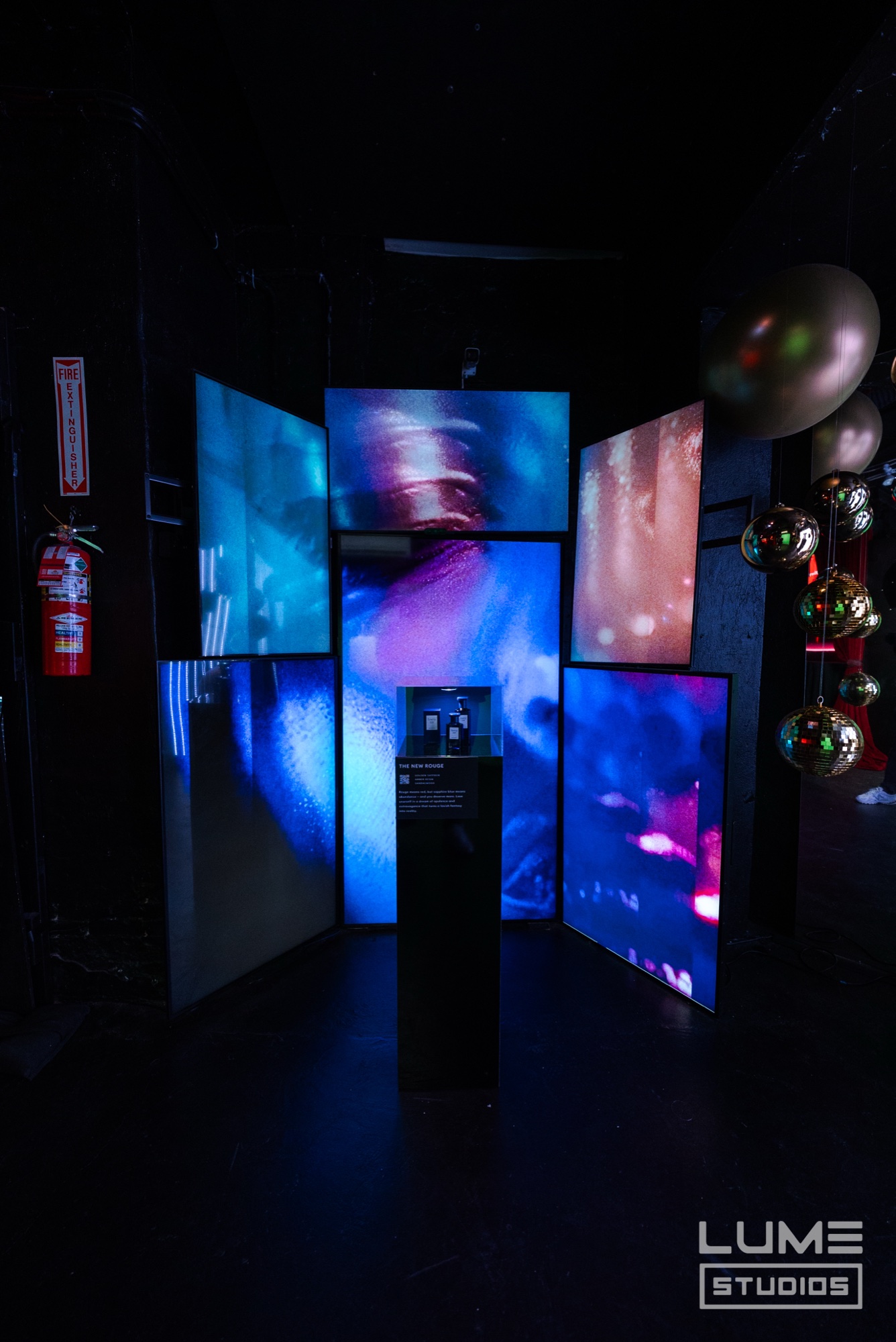 Guests gather at a table of Fine’ry bottles and glassware under a golden projection