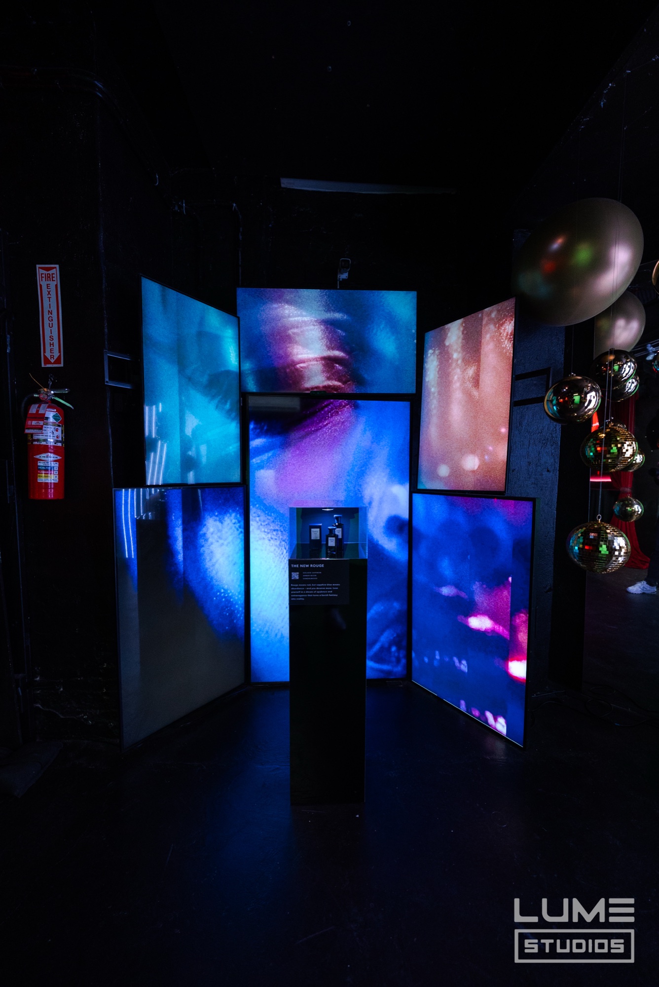 Red room with neon cherries and glowing signs reading luscious, indulgent, sweet at Fine’ry