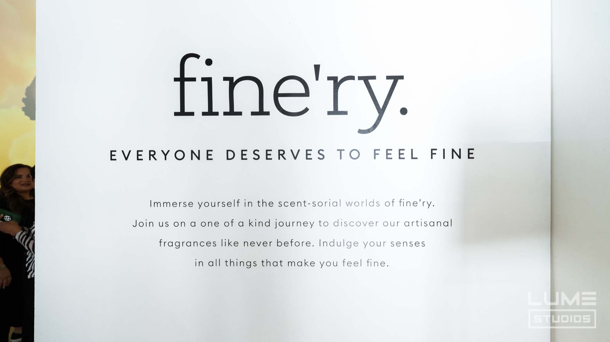 White wall panel with the fine’ry wordmark and the line Everyone Deserves To Feel Fine printed below