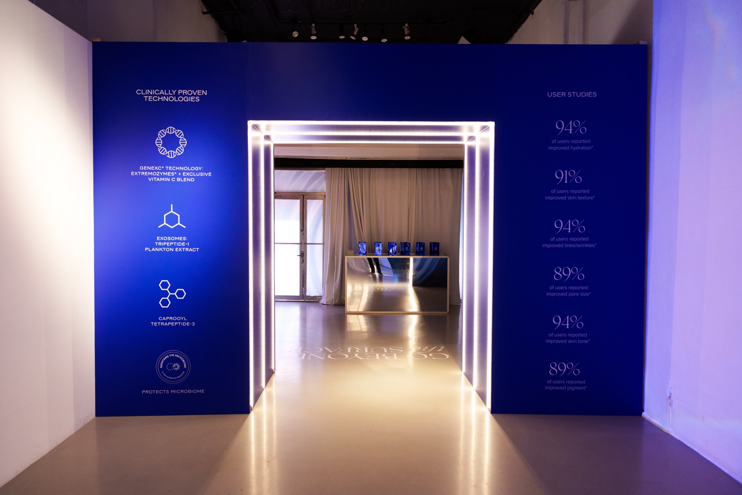Deep blue portal edged in white LED light opens onto a bright display room, percentages printed on the panels