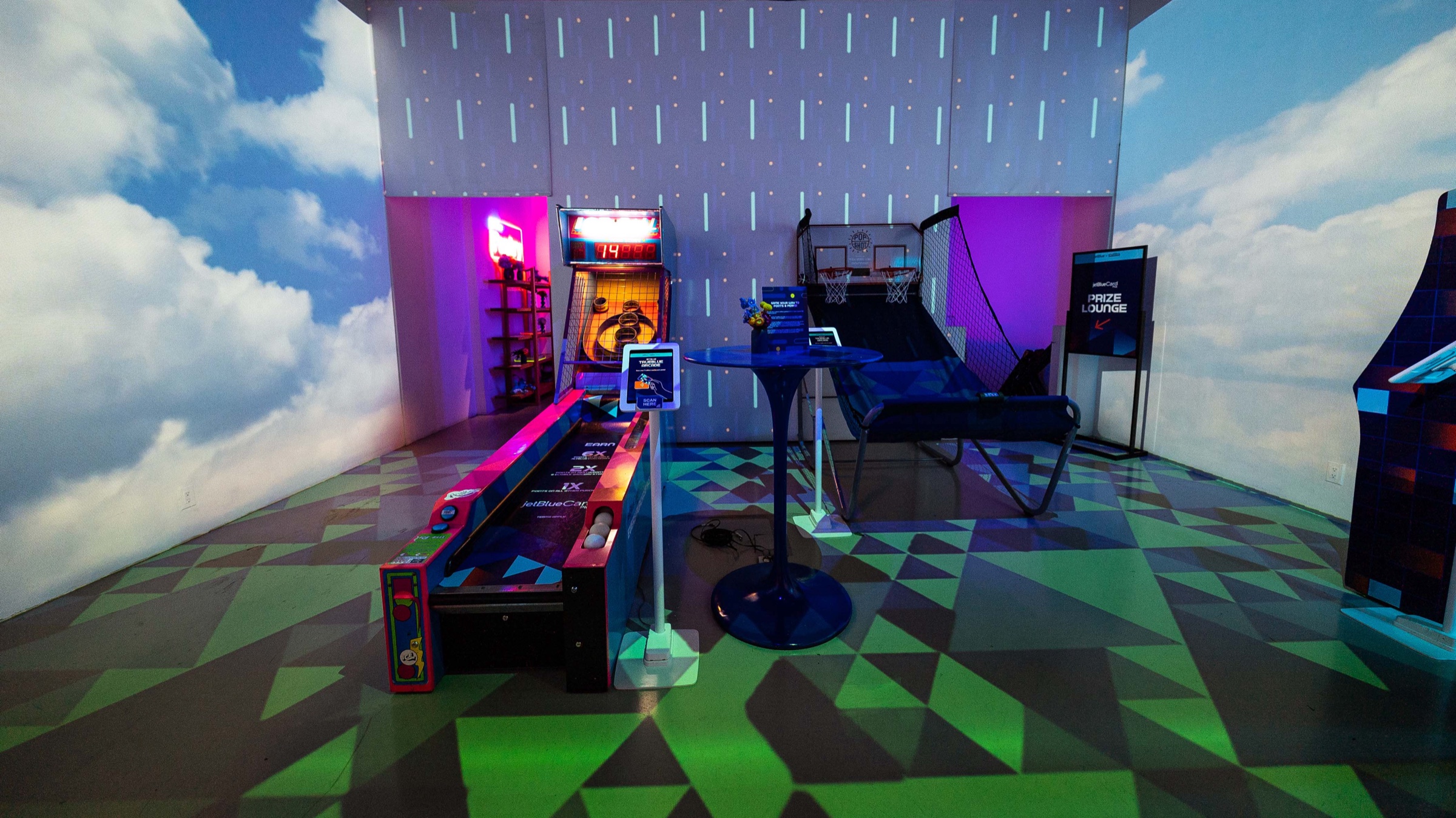 JetBlue TrueBlue arcade room with game cabinets, foosball and cloud projections across the walls
