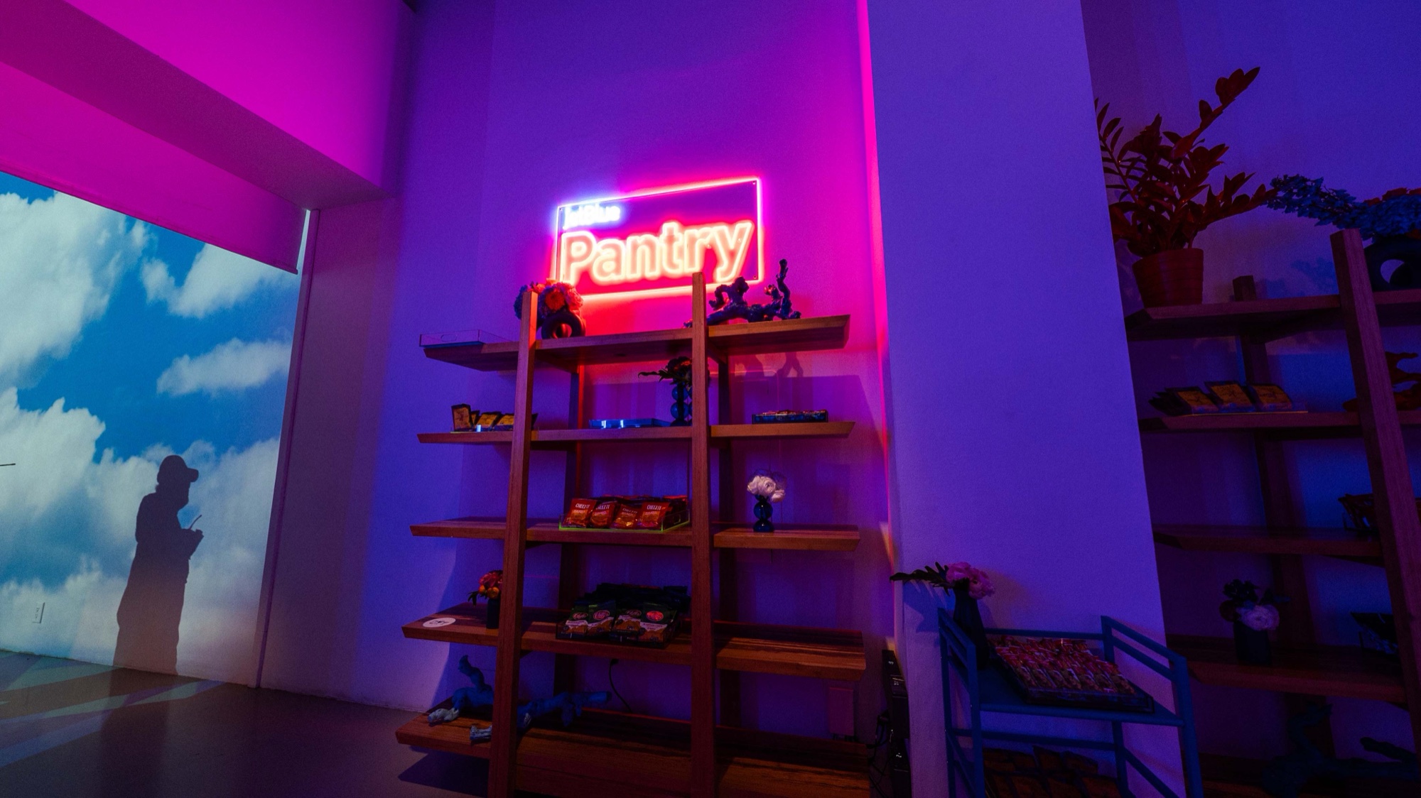 Foosball table with orange accents faces arcade cabinets before a wall of projected clouds at the JetBlue event