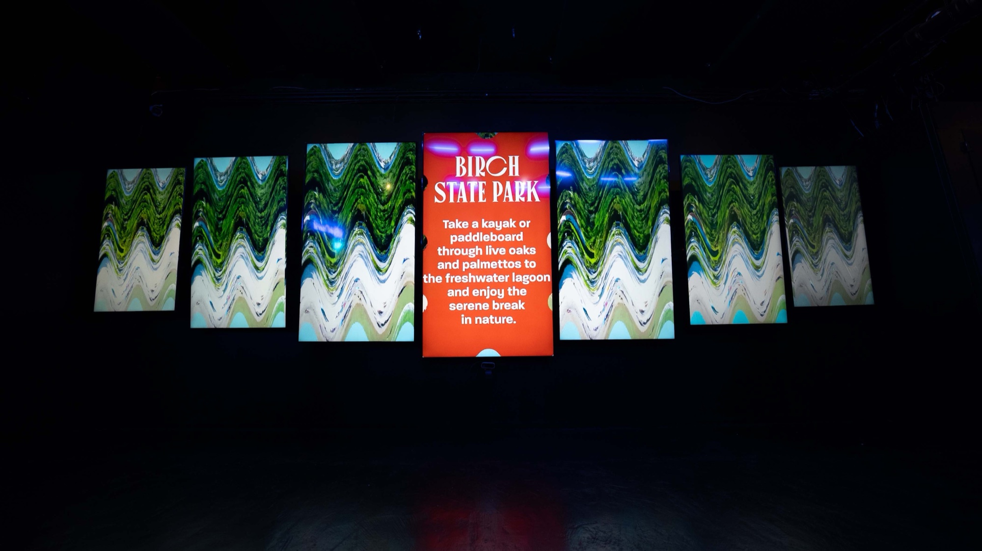 Skee ball lane branded with JetBlue Card glows pink and blue beneath a lit score display