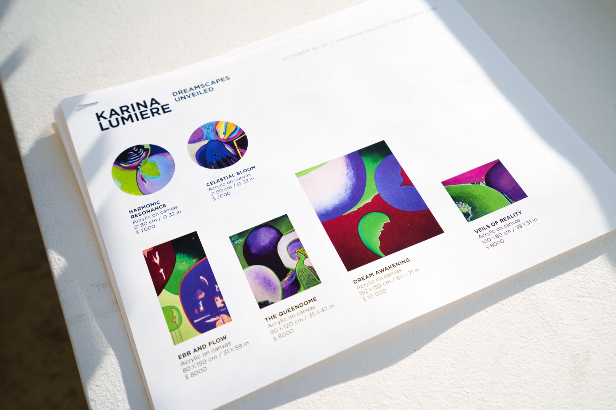 A printed price sheet titled Karina Lumiere Dreamscapes Unveiled showing six colourful abstract paintings
