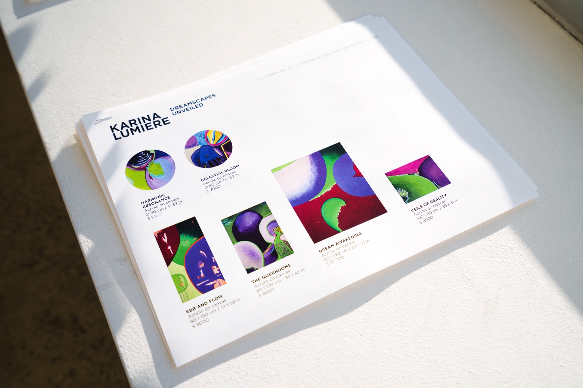 Karina Lumiere exhibition sheet showing colourful abstract paintings resting on a white plinth