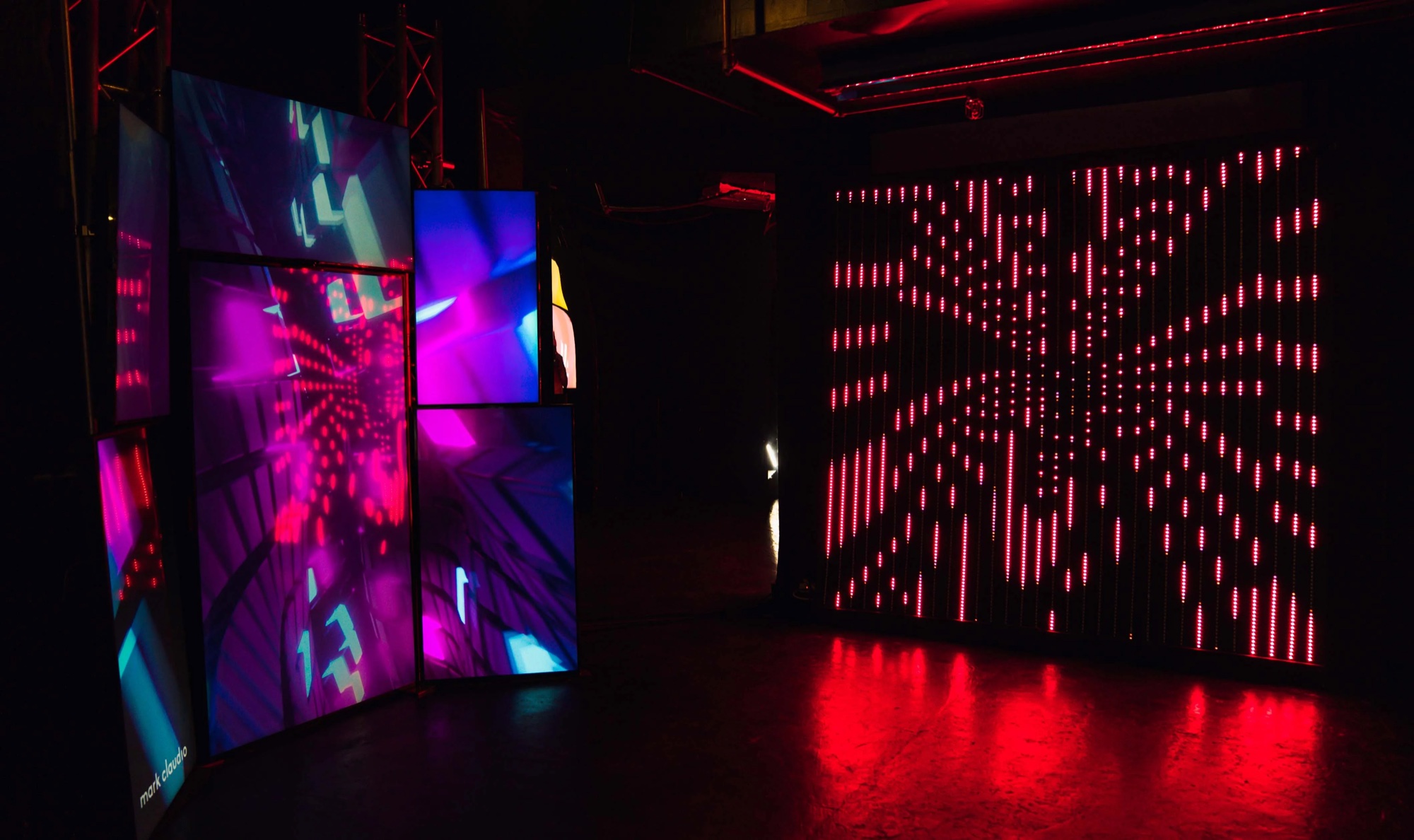 Tilted screens and a red LED wall glow in the dark at the Metaplex party