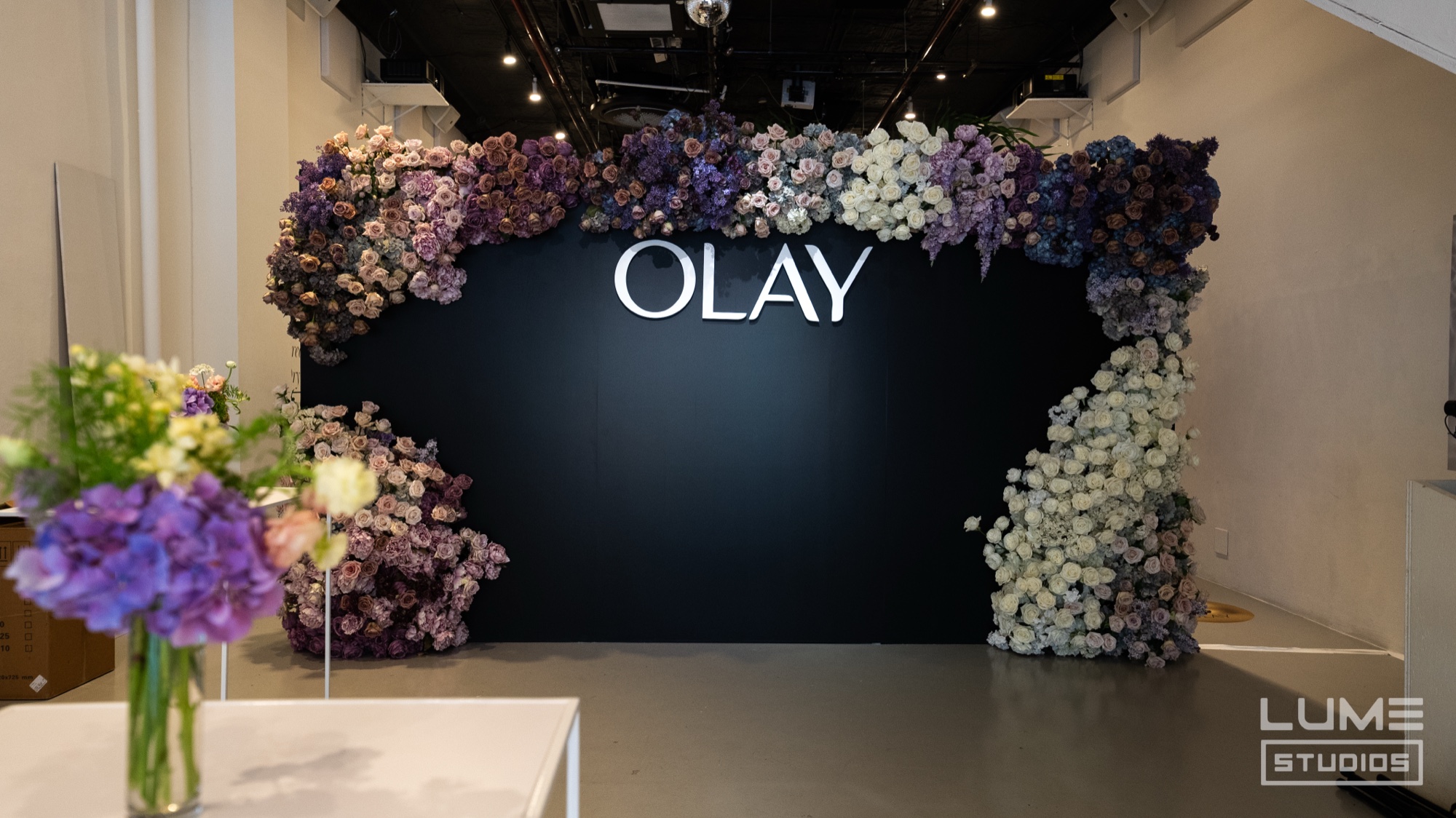 Row of orange spritz cocktails garnished with orange slices at the OLAY Body Labs bar