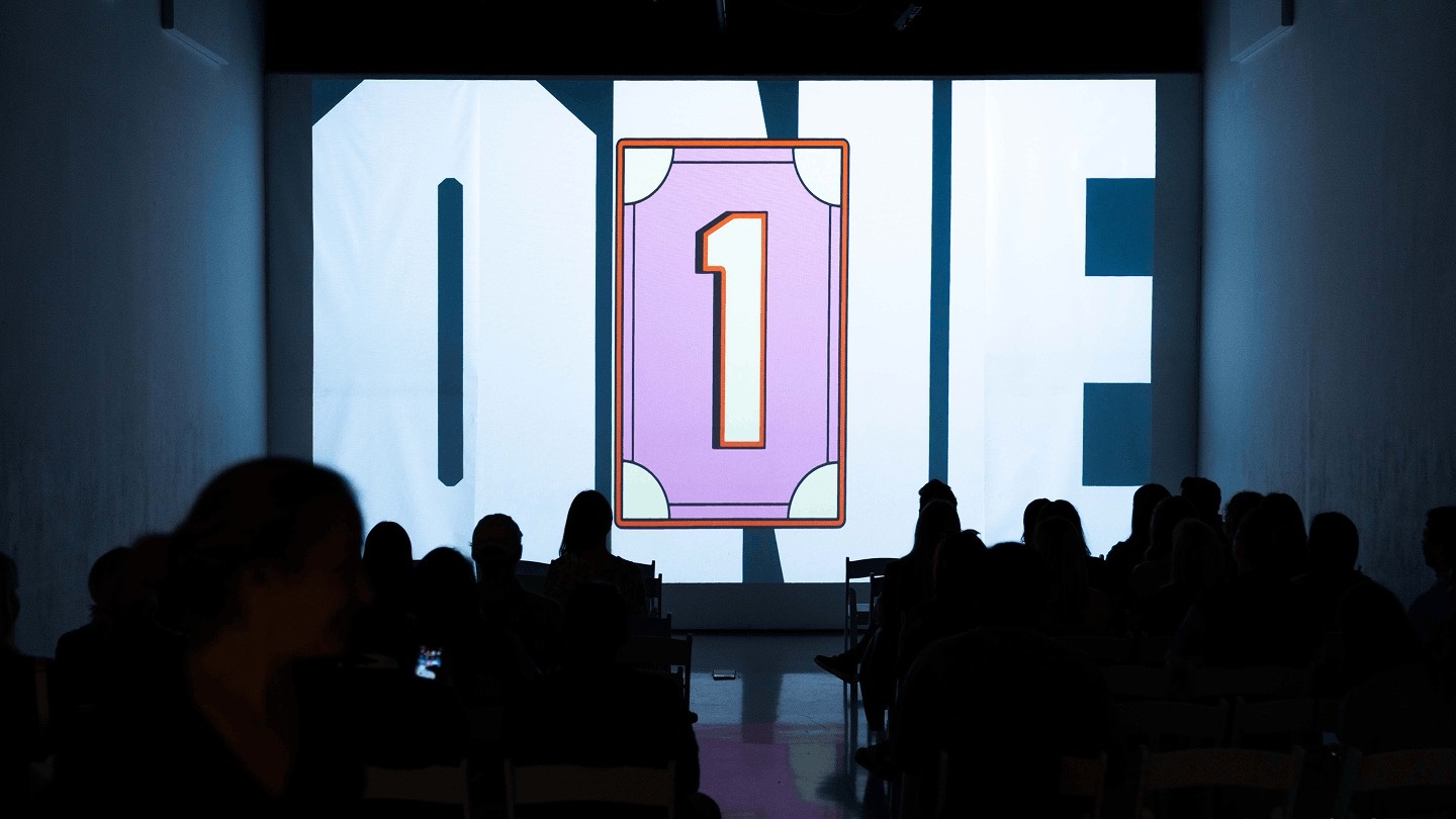 Audience silhouettes watch a giant ONE card graphic on screen at the Pinterest event