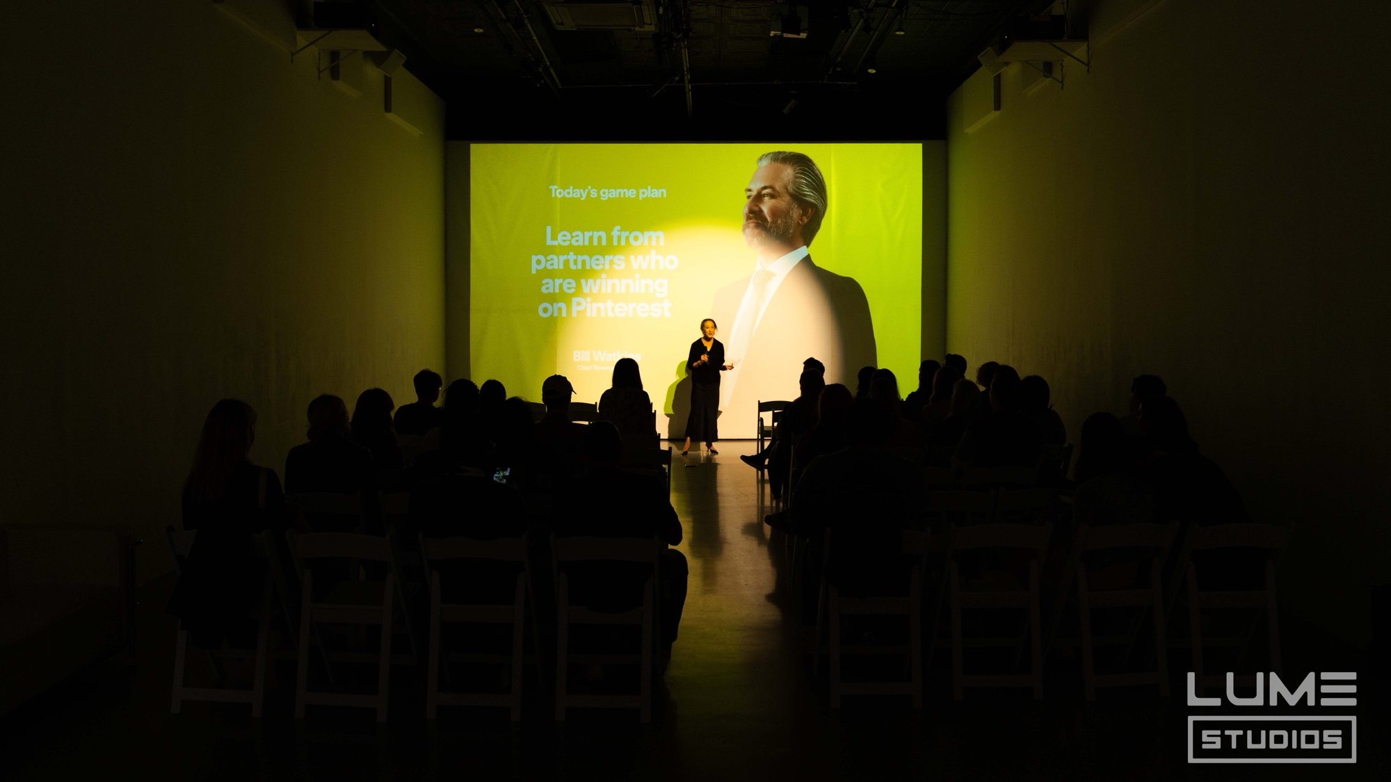 Speaker on stage under a green Pinterest slide about learning from winning partners