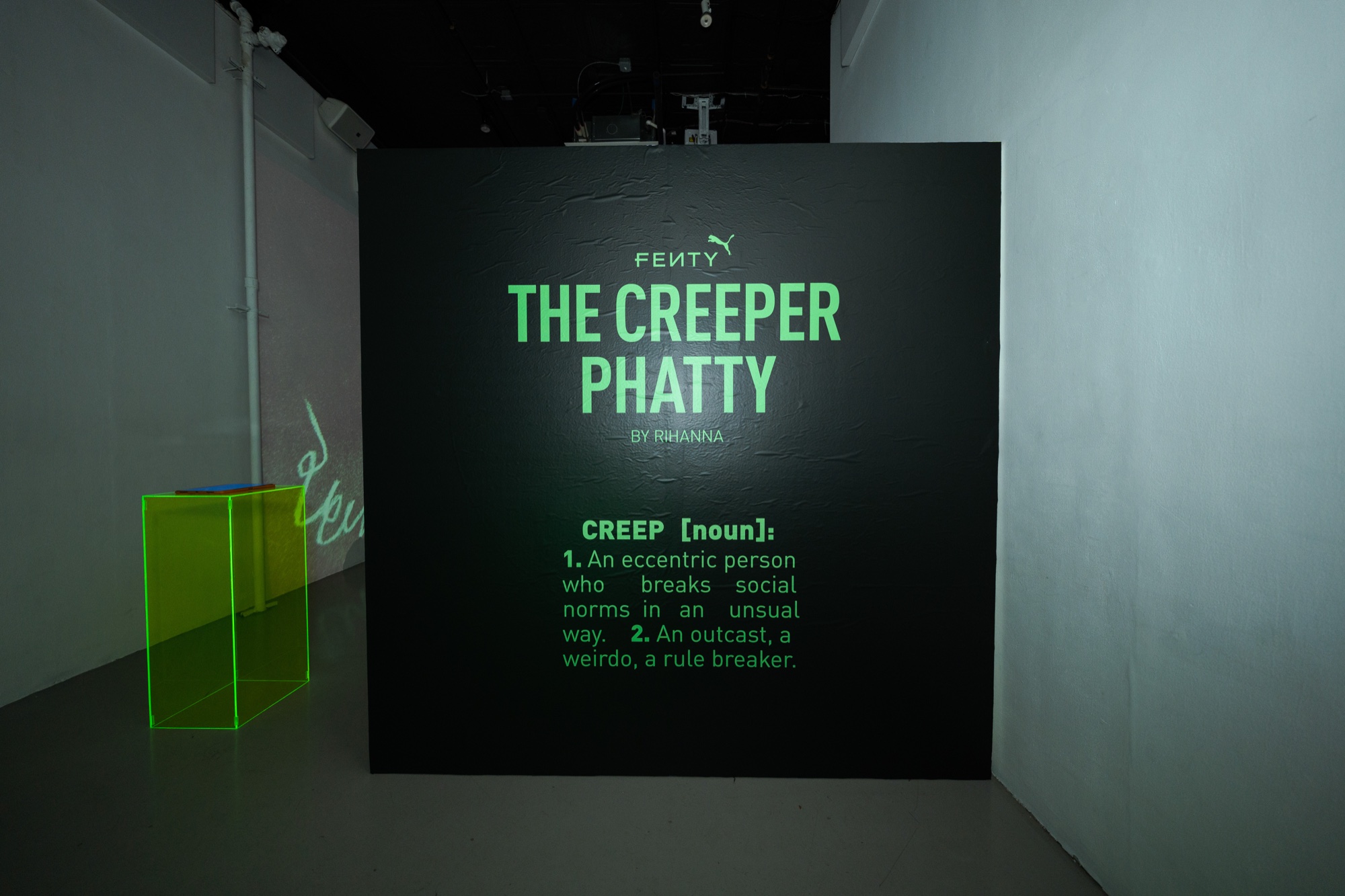 A black wall printed in green with Fenty The Creeper Phatty and a definition of the word creep