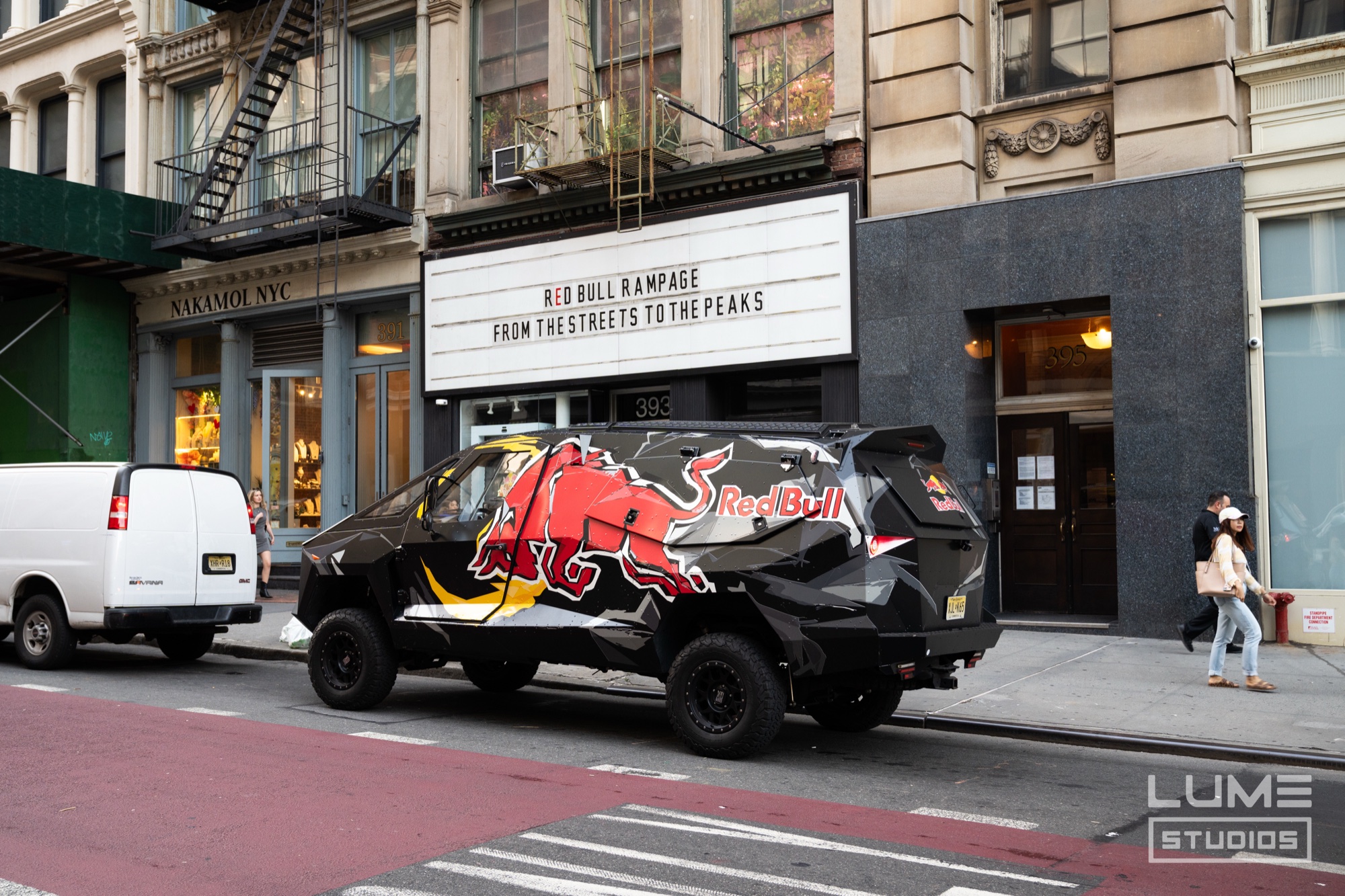 Black pickup truck wrapped with a Red Bull logo parked beneath a marquee reading Red Bull Rampage