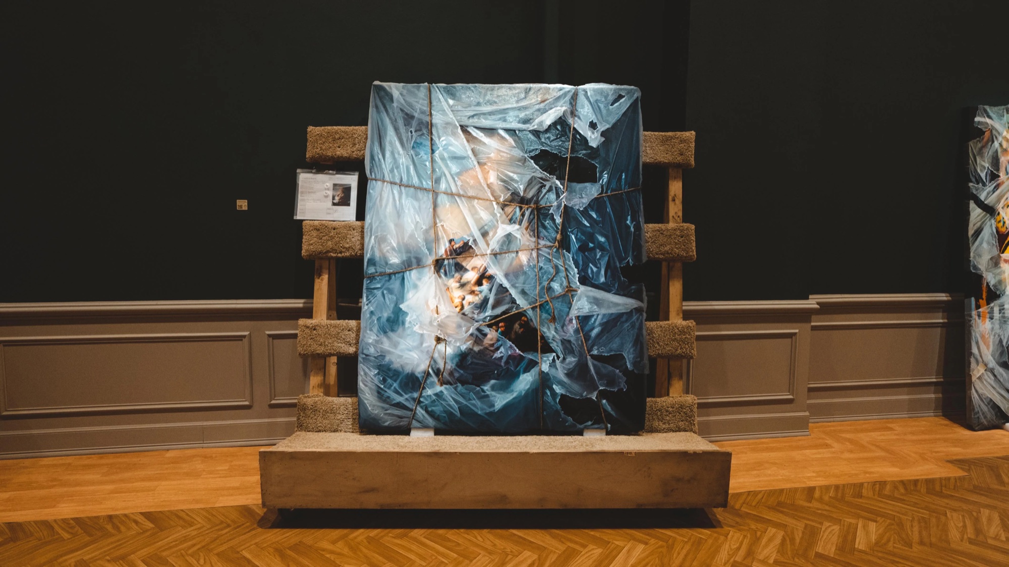 Painting sealed in plastic sheeting on a wooden pallet at the Robin Eley show