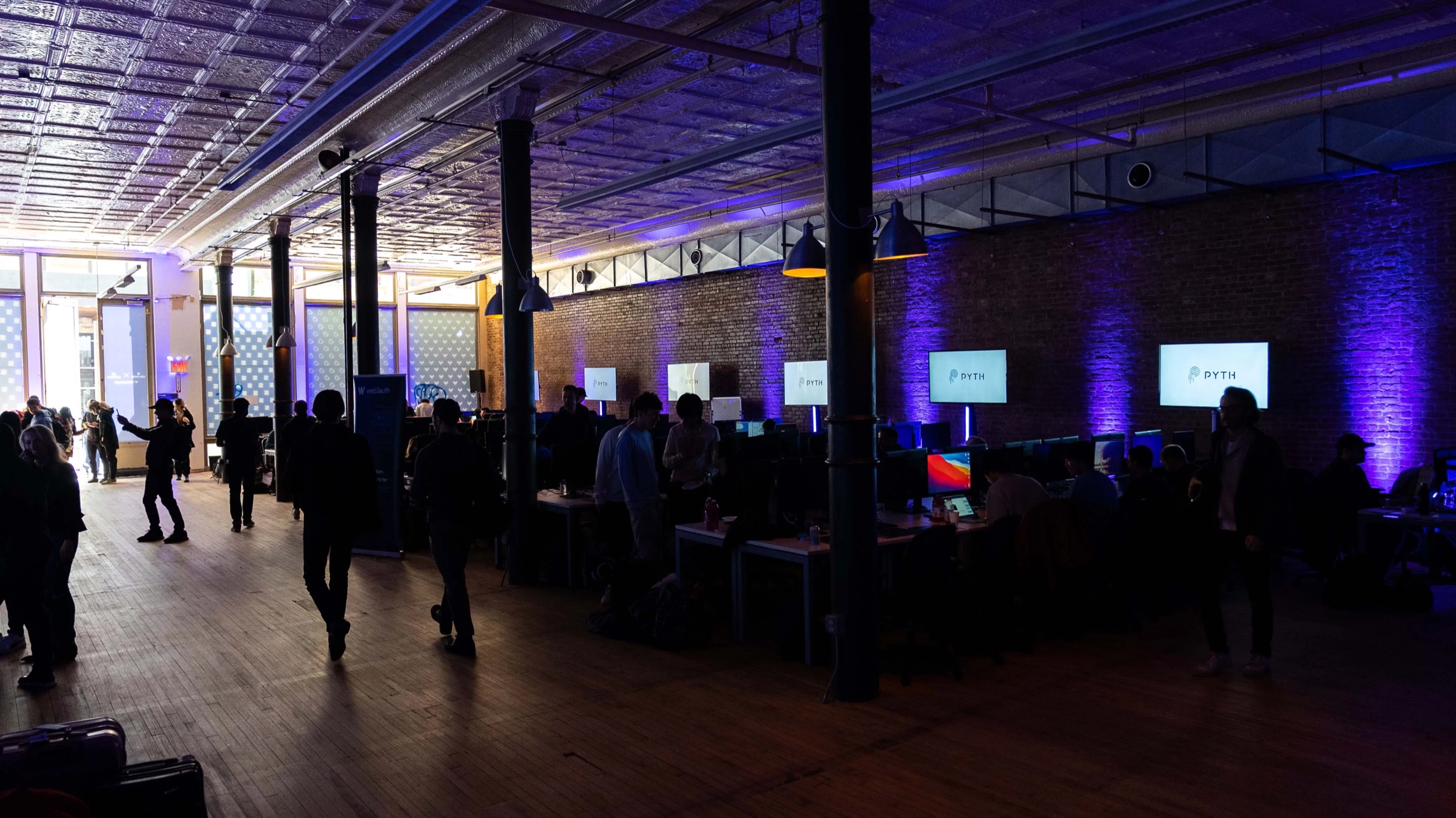 Brick walled loft with rows of workstations and glowing screens during the Solana NYC bootcamp