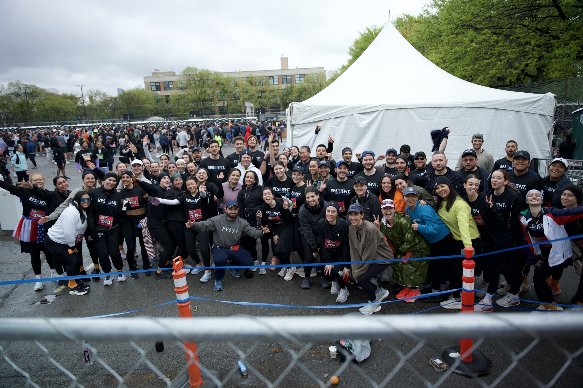 The team lined up behind the barrier in matching black shirts with white tents behind them