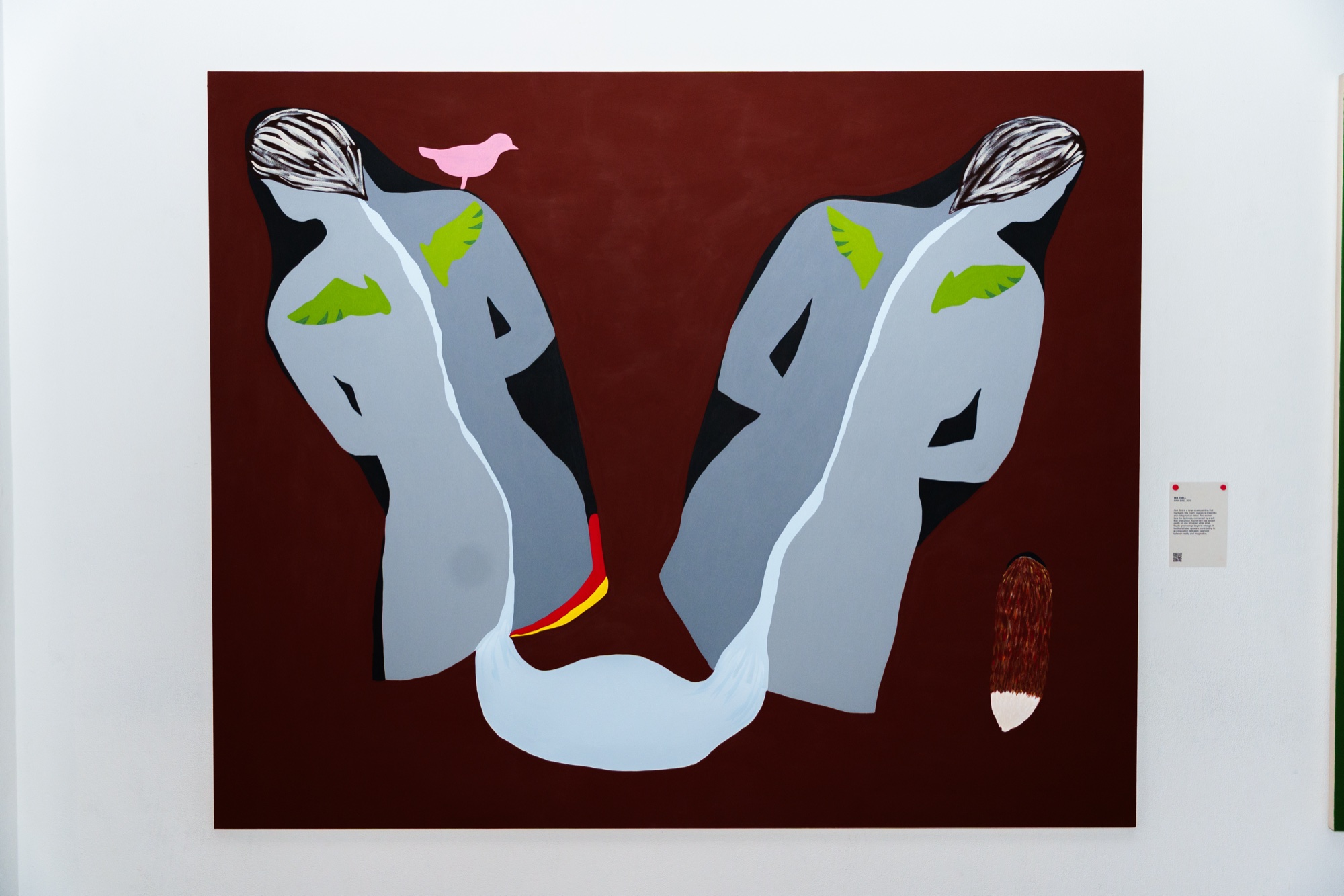 A painting of two grey figures with green wings on a dark red ground, a pink bird on one head