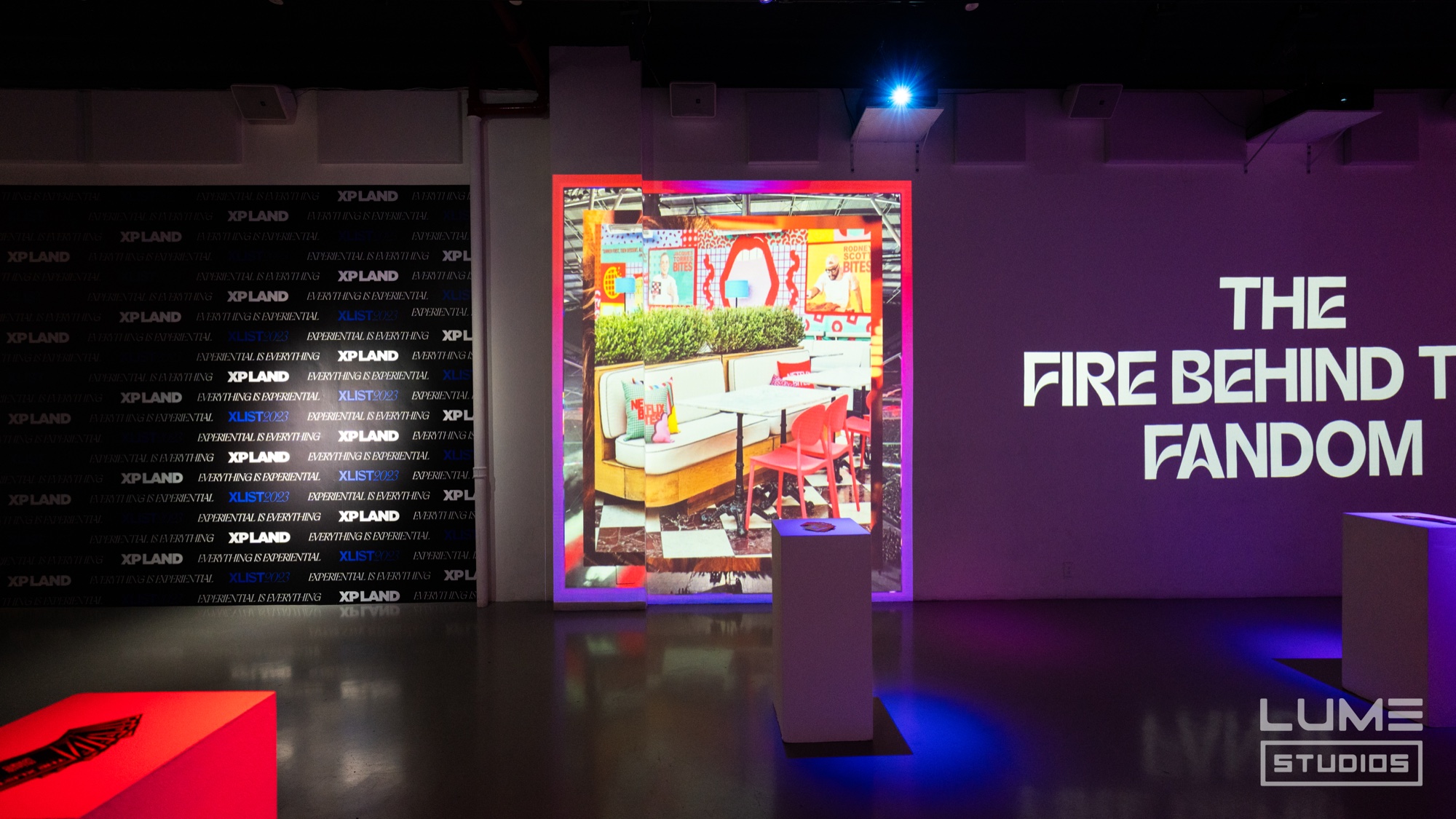 Guests mingle among projected XLIST 2023 category walls naming curators, brand builders and architects