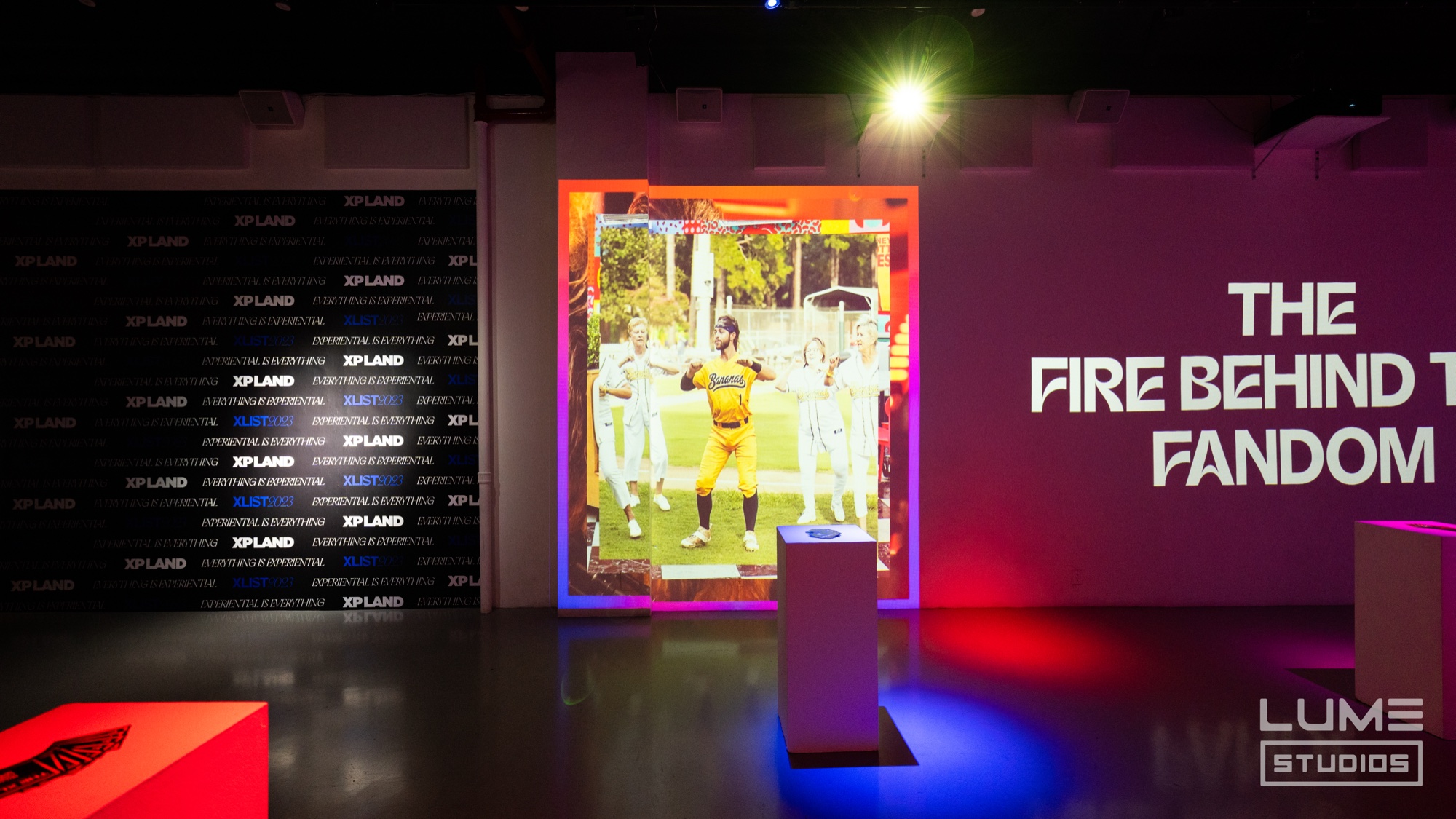 Glowing framed print of an athlete in yellow beside a wall reading The Fire Behind The Fandom